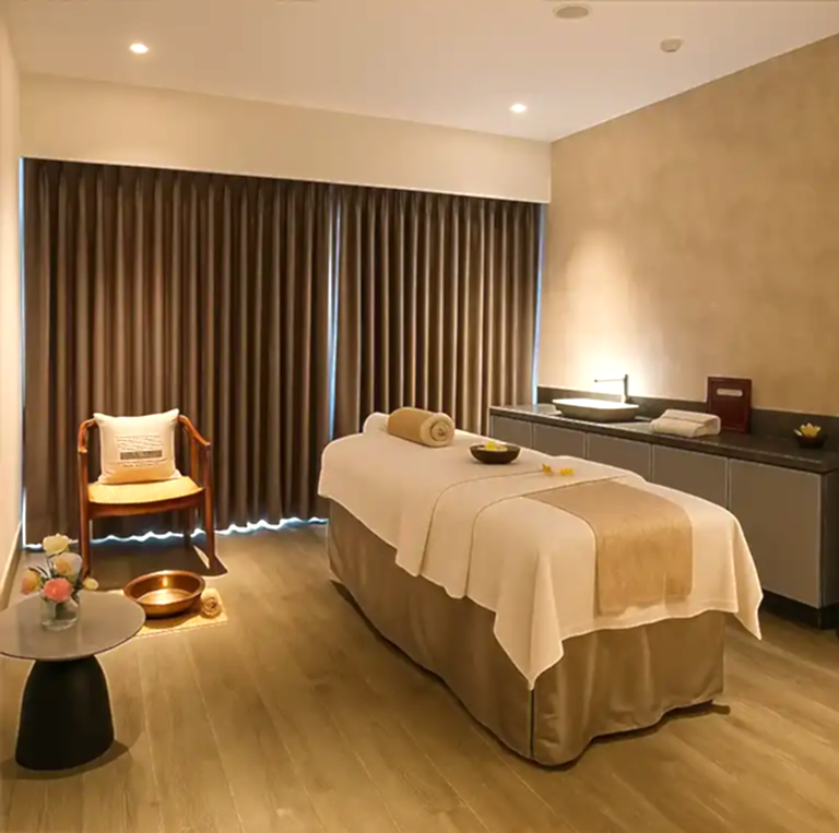 Tranquil massage room at Unora Spa Radisson Blu Mumbai Airport with soft lighting and neutral decor.