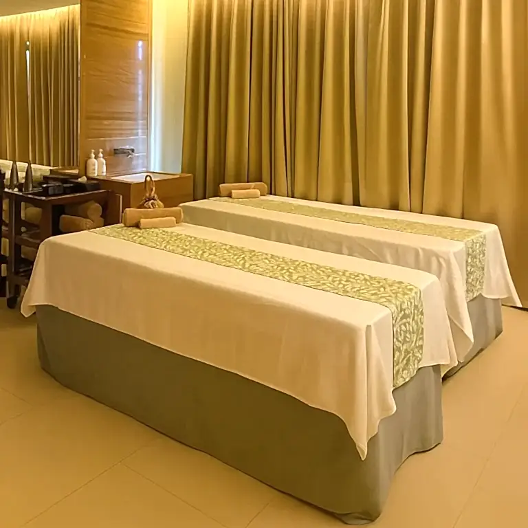Couple massage room at Tattva Wellness Spa in Holiday Inn Sakinaka Mumbai with twin beds and warm lighting.
