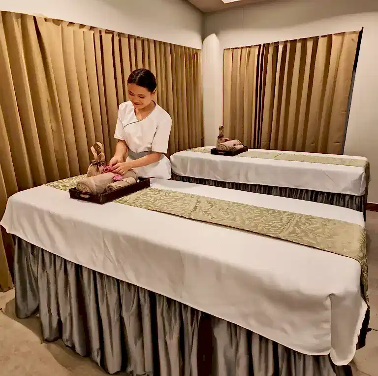 Spa therapist preparing the massage bed at Tattva Spa in Vasundhara Jaipur, with neatly arranged linens and a calm wellness ambiance.