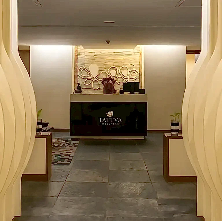 Tattva Spa Radisson Blu Kharadi Pune entrance area with elegant hallway décor, warm lighting, and a modern reception desk featuring artistic wall accents.
