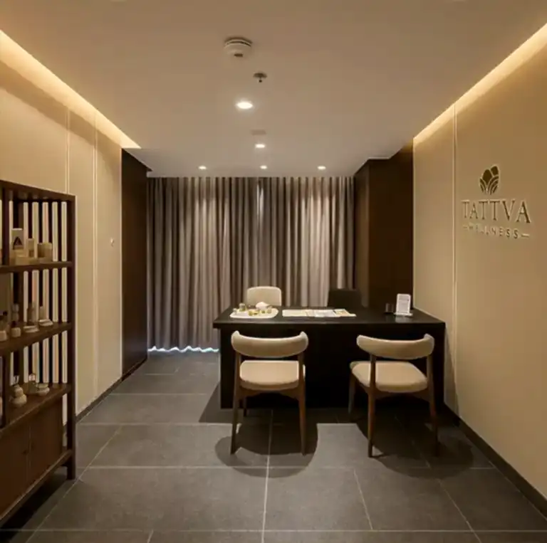 Reception lounge at Tattva Wellness Spa in Country Inn & Suites by Radisson, featuring a minimalist wooden design and soothing atmosphere for guest consultations.